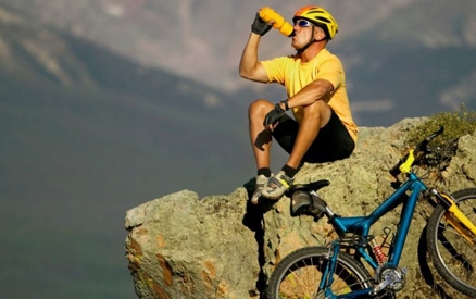 Bicyclist resting on mountain side enjoying view